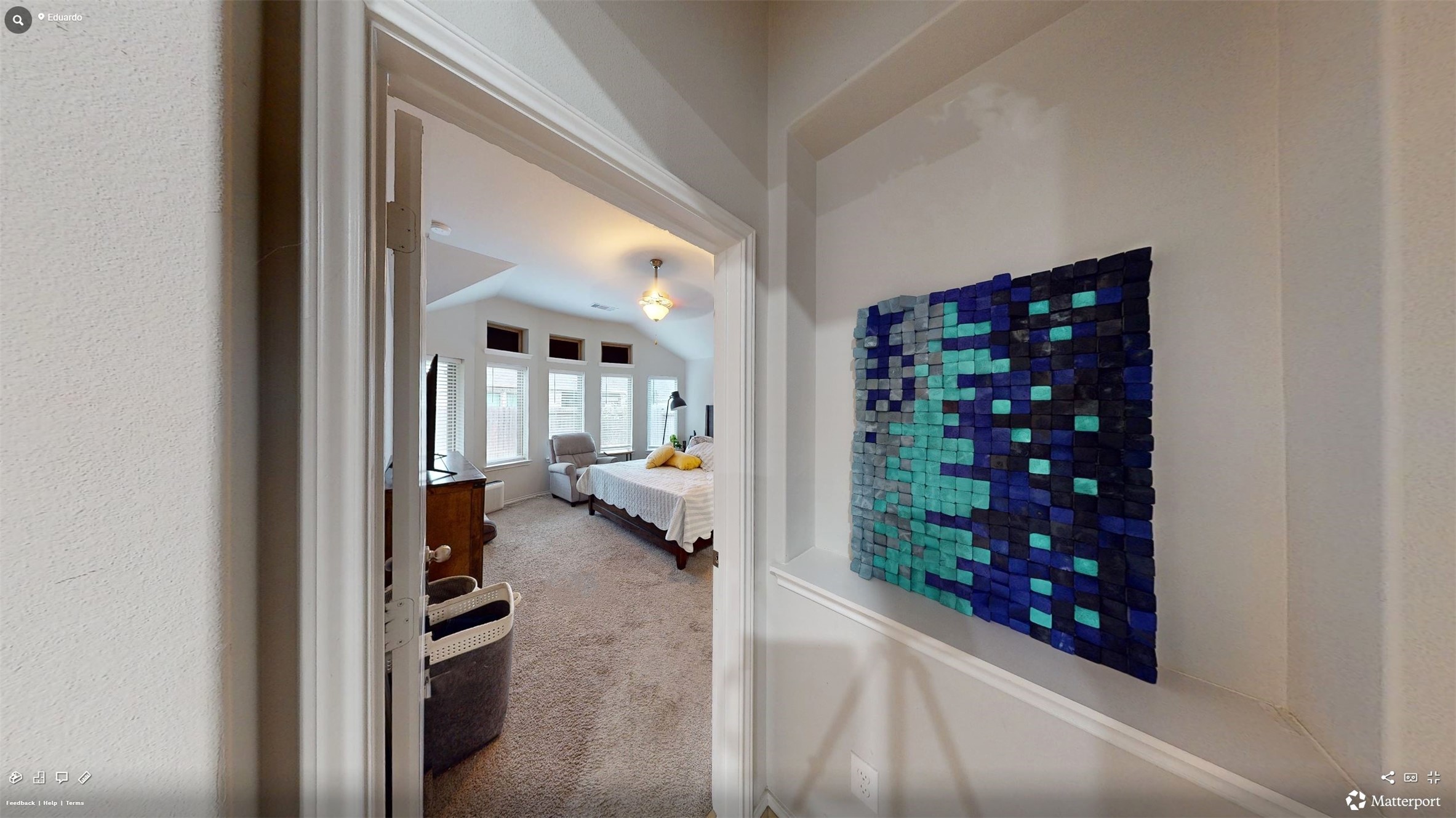 718 Santa Elena Trail Conroe, TX 77304 - Photo 11 of 29 This inviting hallway, adorned with vibrant artwork, seamlessly guides you into the spacious and light-filled primary bedroom, offering a perfect blend of style and comfort.