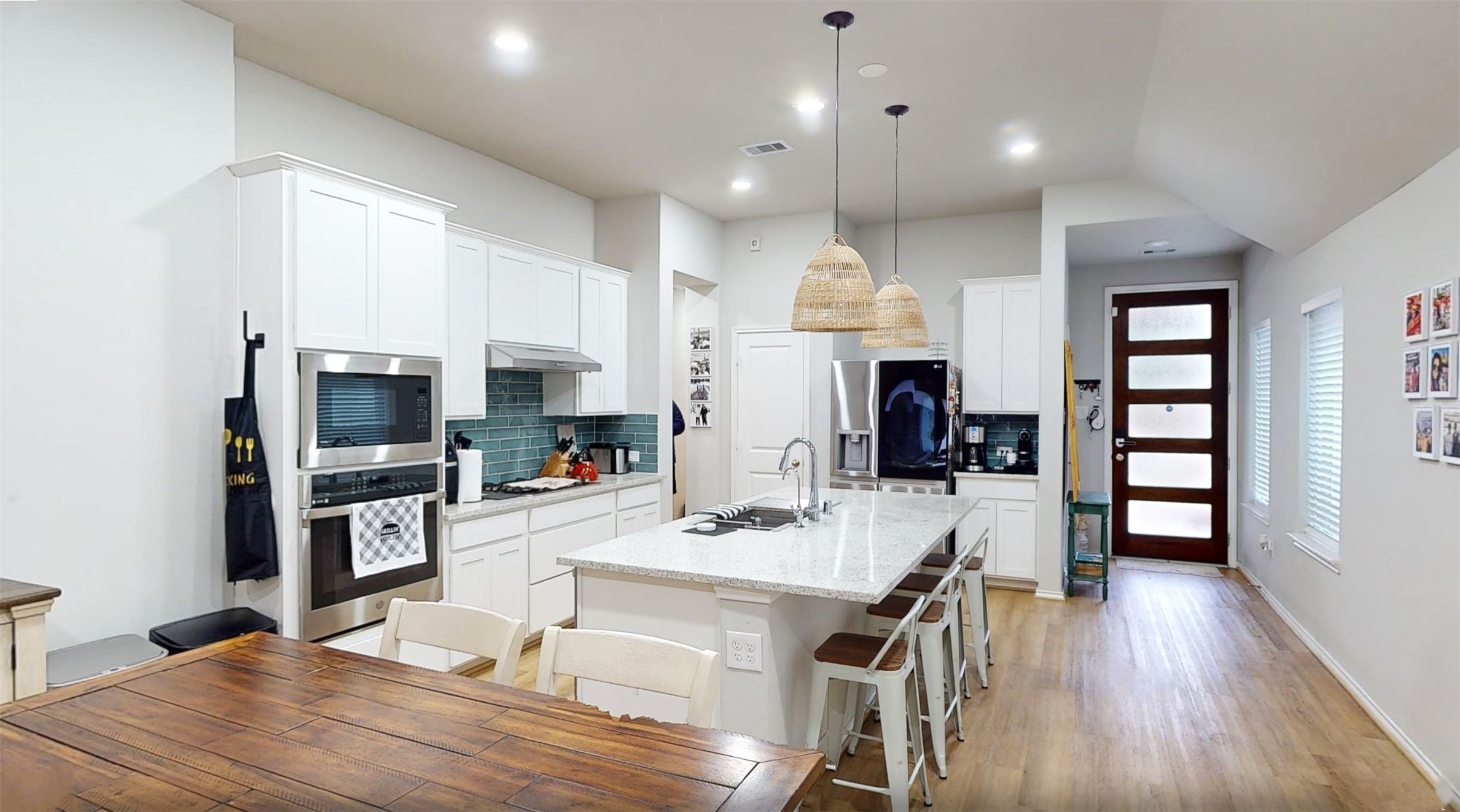 718 Santa Elena Trail Conroe, TX 77304 - Photo 2 of 29 Discover the heart of this home in a bright, modern kitchen featuring sleek white cabinetry, a spacious island with seating, and contemporary lighting, perfect for both everyday meals and entertaining.