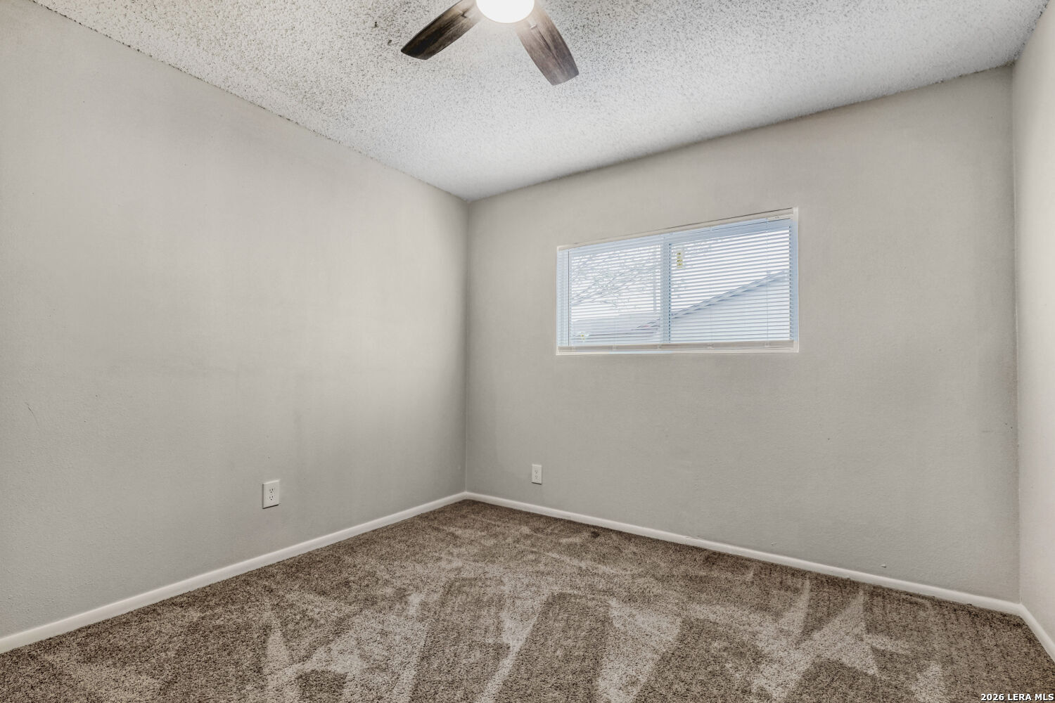 8264 Longhorn Ridge Drive Converse, TX 78109 - Photo 13 of 17 an empty room with a chandelier fan and windows
