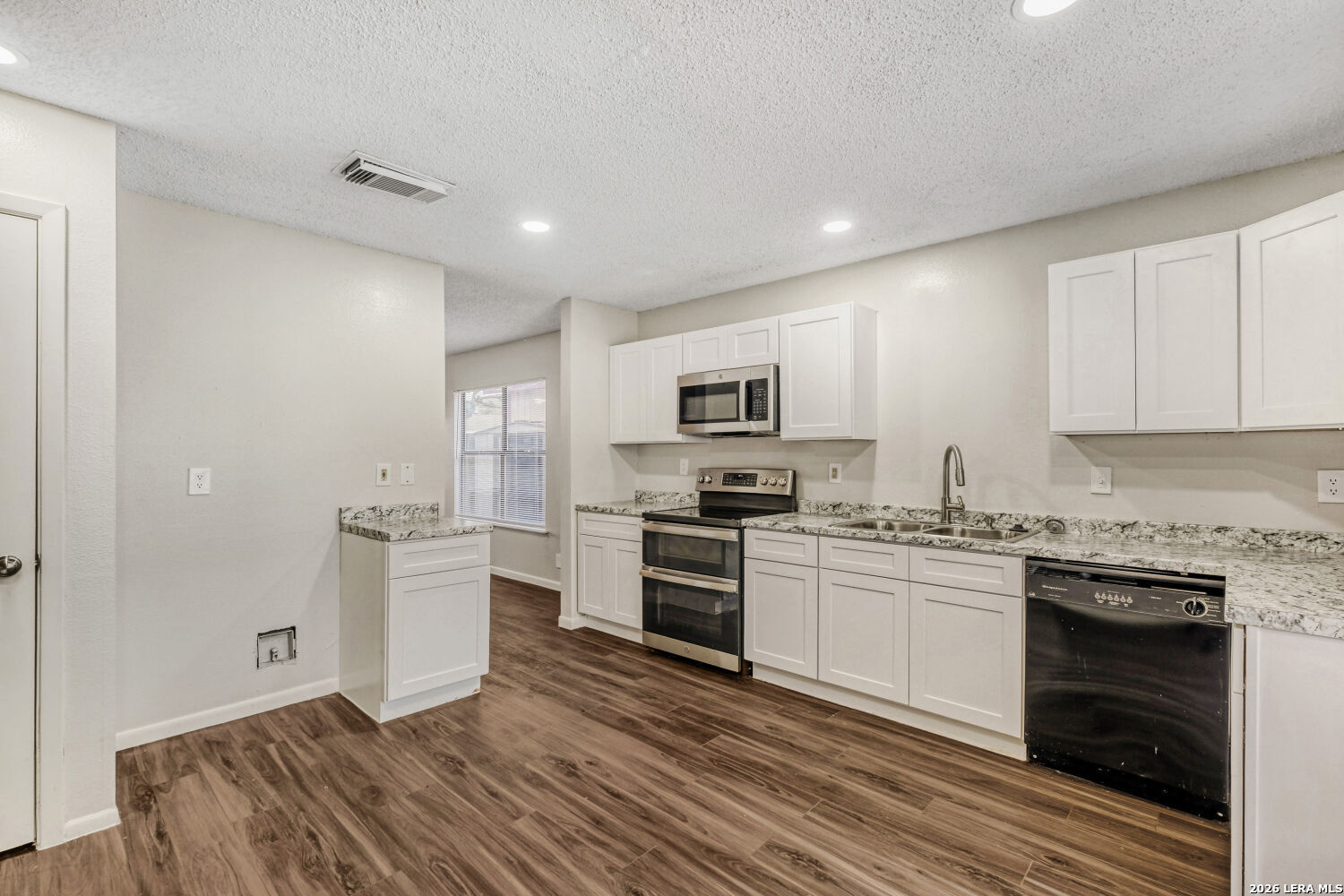8264 Longhorn Ridge Drive Converse, TX 78109 - Photo 6 of 17 a kitchen with white cabinets stainless steel appliances and a fireplace