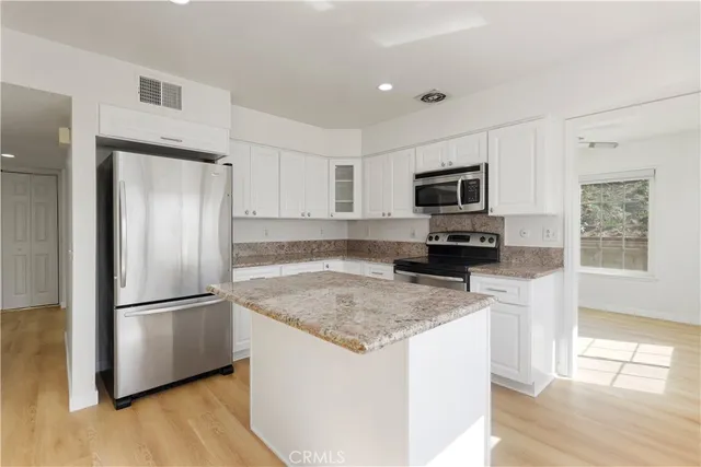 a kitchen with stainless steel appliances granite countertop a stove a sink and a microwave