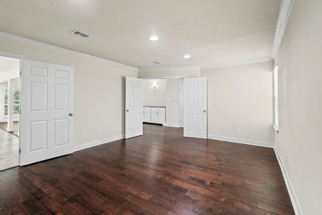 a view of an empty room with wooden floor