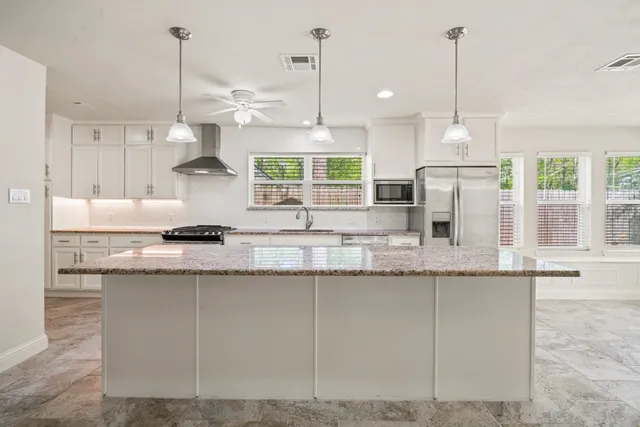 a kitchen with granite countertop a counter a sink and a wooden floor