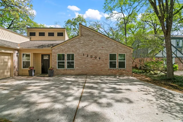 a backyard of a house with large trees and brick walls