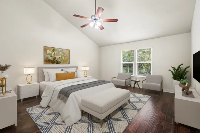 a bedroom with a bed a couch and a potted plant