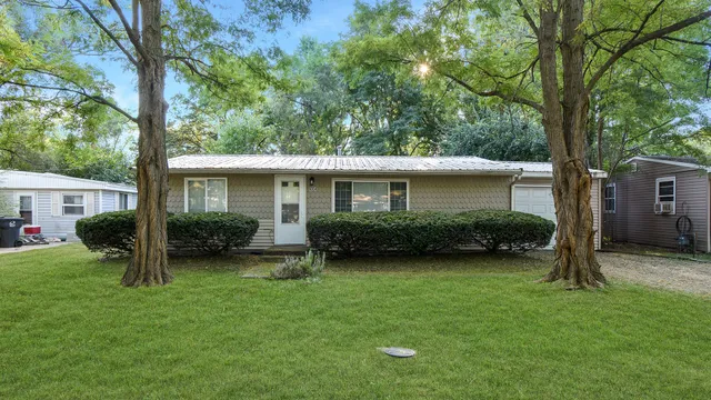 a view of a house with backyard and a tree