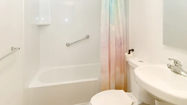 a white toilet sitting next to a bath tub