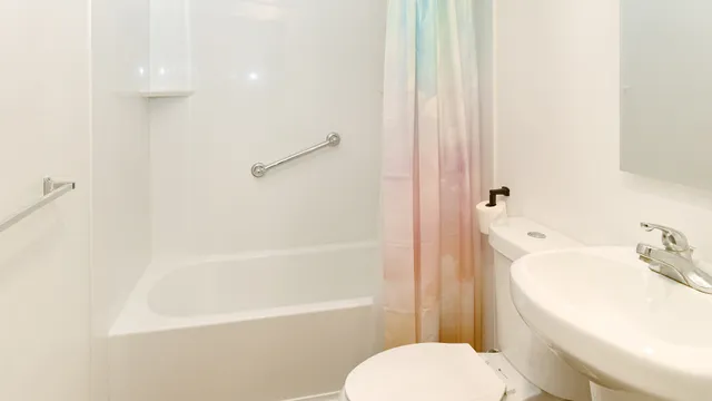 a white toilet sitting next to a bath tub
