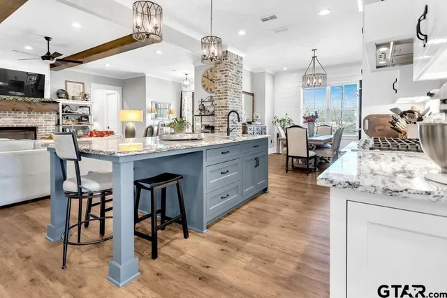 a very nice looking living room with stainless steel appliances kitchen island granite countertop furniture wooden floor and view living room