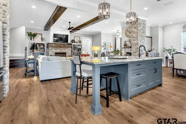 a kitchen with stainless steel appliances kitchen island granite countertop a stove a sink and white cabinets
