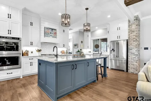 a kitchen with stainless steel appliances granite countertop a refrigerator and a stove top oven