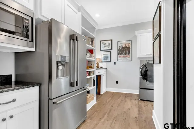 a kitchen with a refrigerator and white cabinets