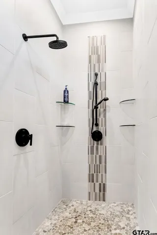 a bedroom with a bed a chandelier and a painting on the wall