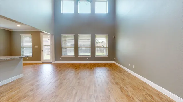 a view of a livingroom with wooden floor and a large window