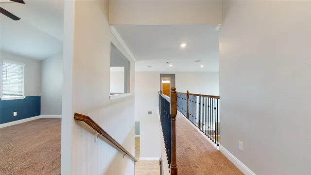 an empty room with a chandelier fan and windows