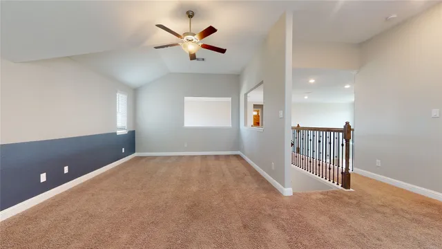 an empty room with a window and a ceiling fan