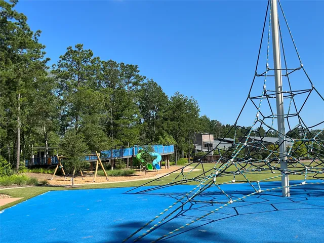 a view of a swimming pool with a bench and trees
