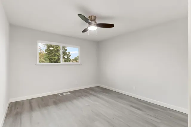 a room with a wooden floor and white walls