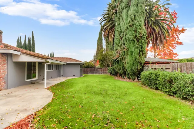 a view of a house with a yard and table