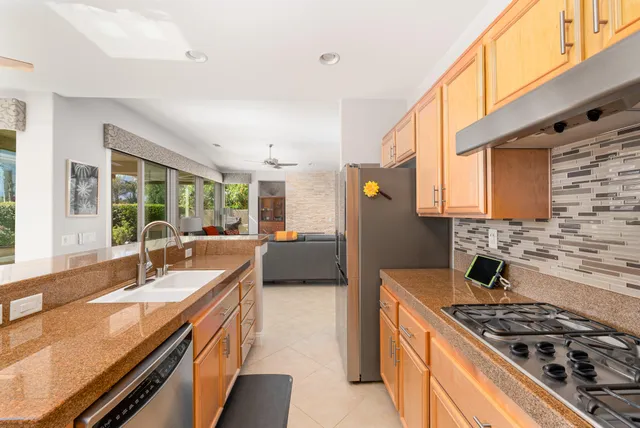 a kitchen with stainless steel appliances granite countertop a stove a sink and a microwave