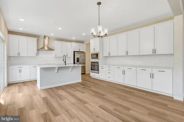 a large kitchen with stainless steel appliances a sink and a large window