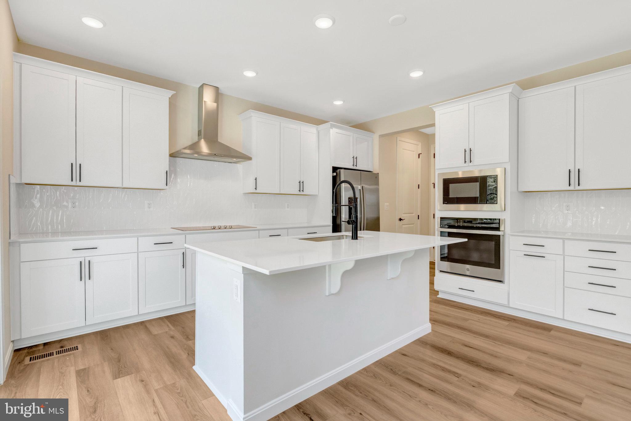 35670 Aspen Way Locust Grove, VA 22508 - Photo 16 of 60 a kitchen with stainless steel appliances granite countertop a stove a sink and white cabinets with wooden floor