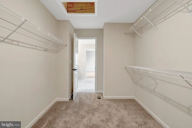 a view of an empty room with window and closet area