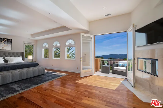 a view of a big room with wooden floor and windows