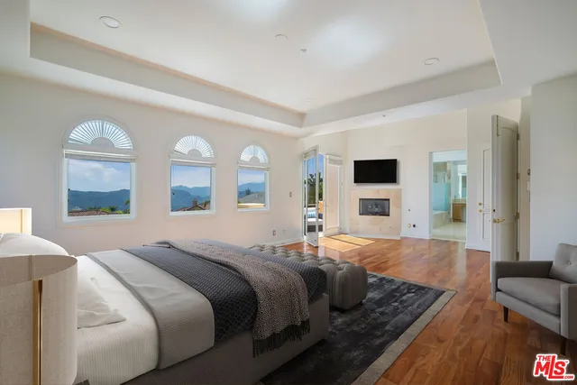 a view of empty room with wooden floor and fireplace