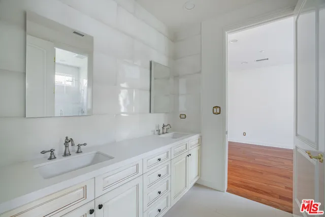 a bedroom with two beds and wooden floor