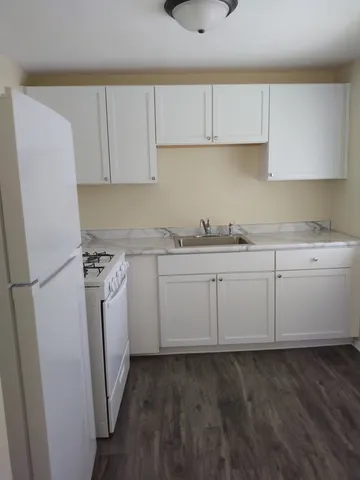 a kitchen with a sink a refrigerator a stove and cabinets