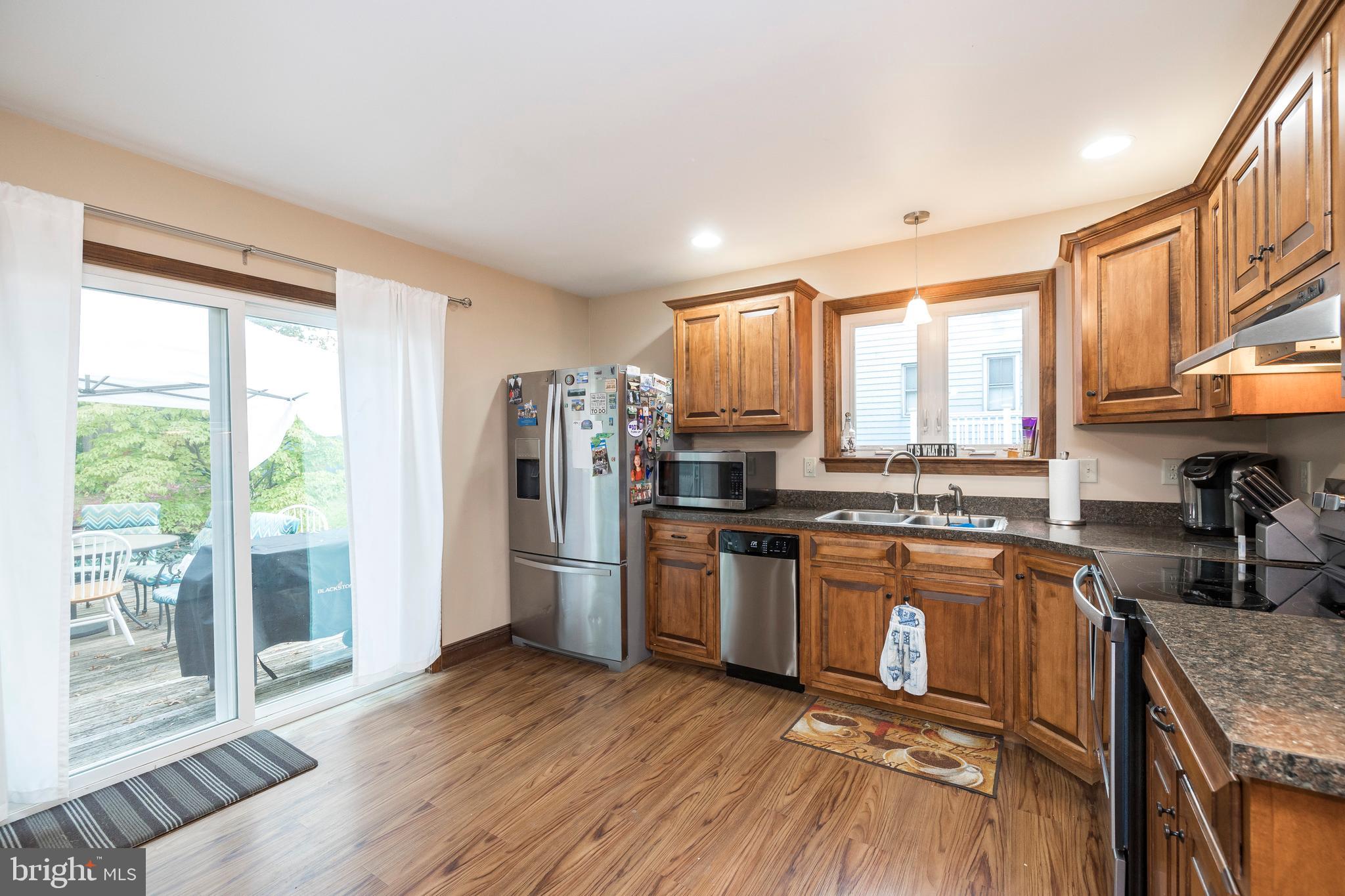 128 Chestnut Street Spring City, PA 19475 - Photo 14 of 32 a kitchen with stainless steel appliances granite countertop a stove top oven a refrigerator a sink and a granite counter tops with wooden floors