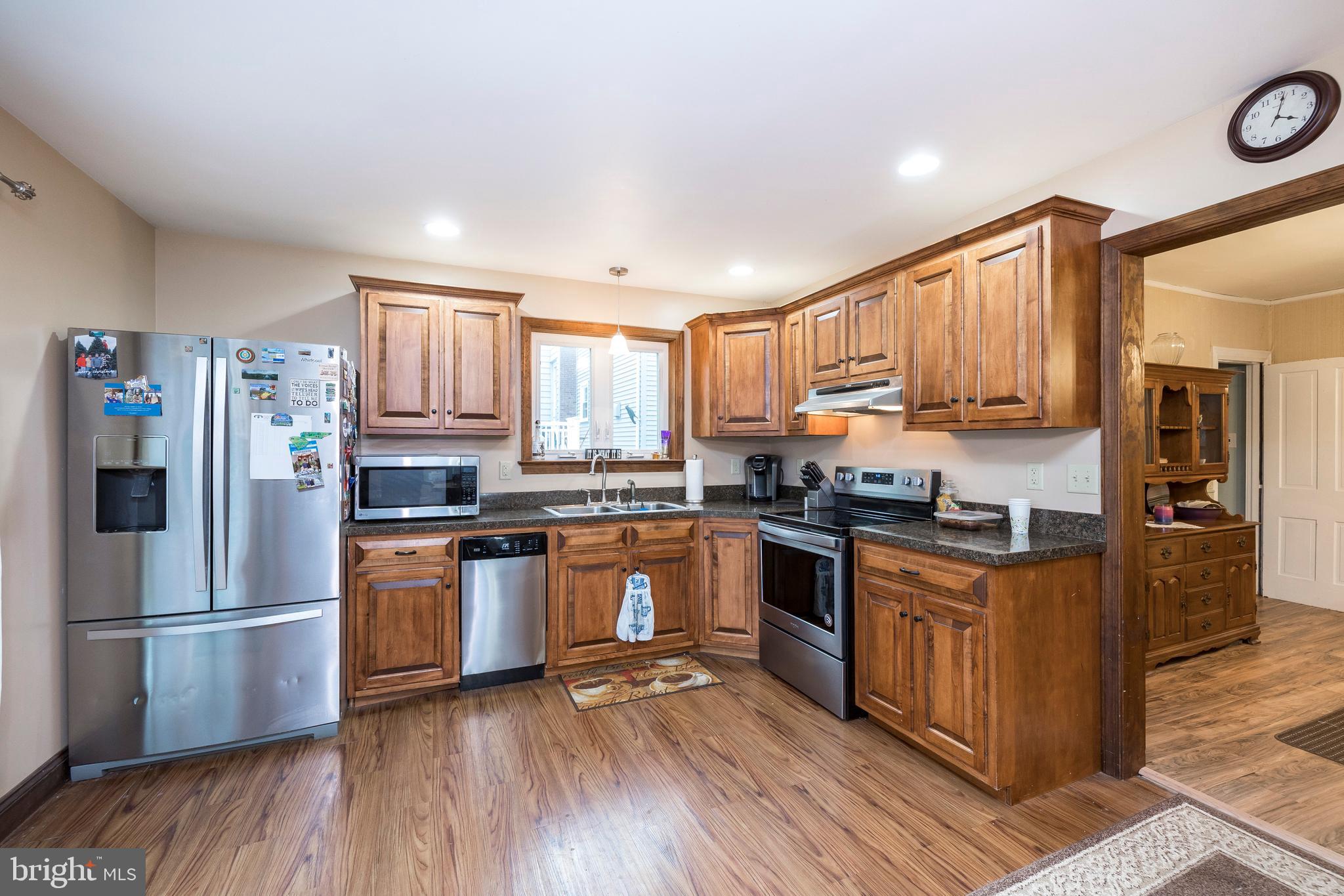 128 Chestnut Street Spring City, PA 19475 - Photo 15 of 32 a kitchen with stainless steel appliances granite countertop a refrigerator a stove top oven a sink and dishwasher with wooden floor
