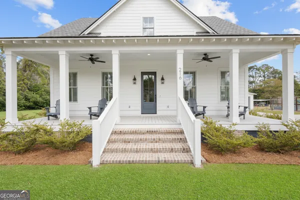 a front view of a house with a garden and plants
