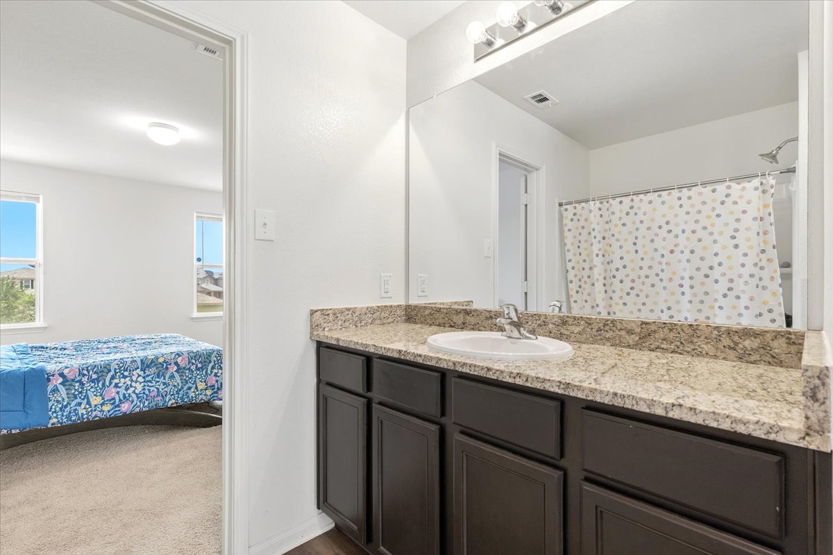 19808 Hubert R Humphrey Road Manor, TX 78653 - Photo 23 of 37 A well-appointed bathroom vanity with granite counters offers everyday convenience.