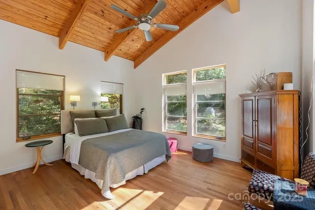 a bedroom with a bed and wooden floor