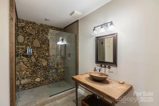 a bathroom with a sink a mirror and shower