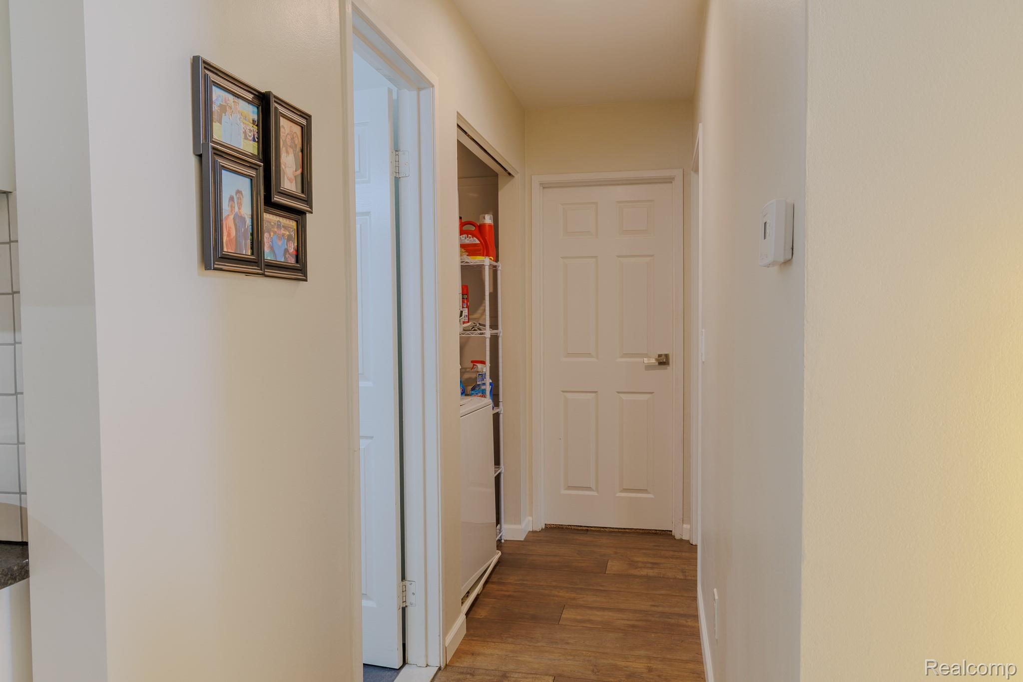 1989 Klingensmith Road, Unit 46 Bloomfield Hills, MI 48302 - Photo 22 of 41 Bright hallway featuring wood-finish flooring, light-toned walls, and a built-in storage closet