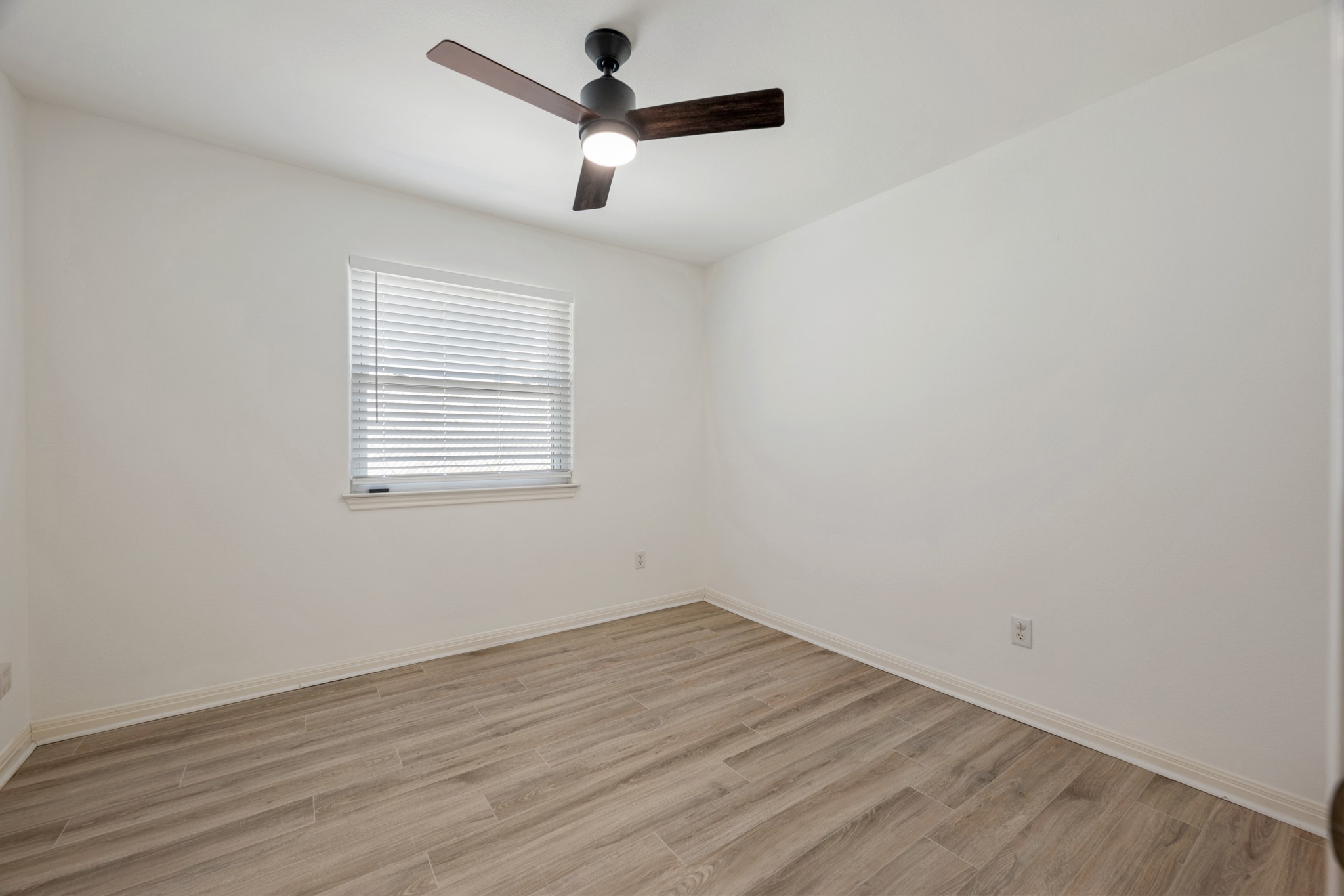 10114 Janet Loop Dripping Springs, TX 78620 - Photo 19 of 34 Crisp walls and modern plank flooring define this versatile secondary bedroom space.