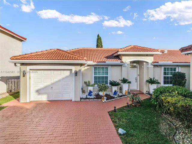 a front view of a house with a garden and plants