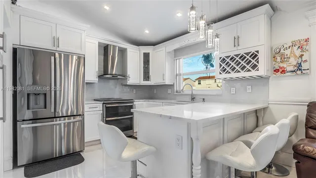 a kitchen with stainless steel appliances granite countertop a refrigerator sink and stove