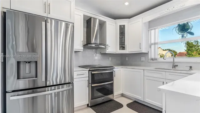 a living room with furniture kitchen view and a window