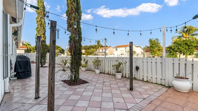 a living room with a large window and potted plants