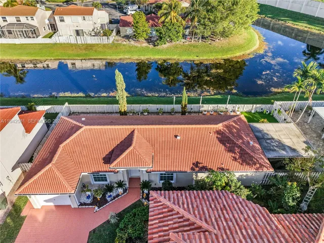 an aerial view of a house with a garden and lake view