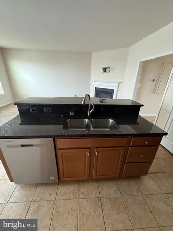 a kitchen with stainless steel appliances granite countertop a table chairs in it and wooden floors