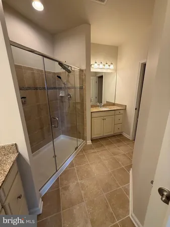 a bathroom with a double vanity sink a mirror and a shower