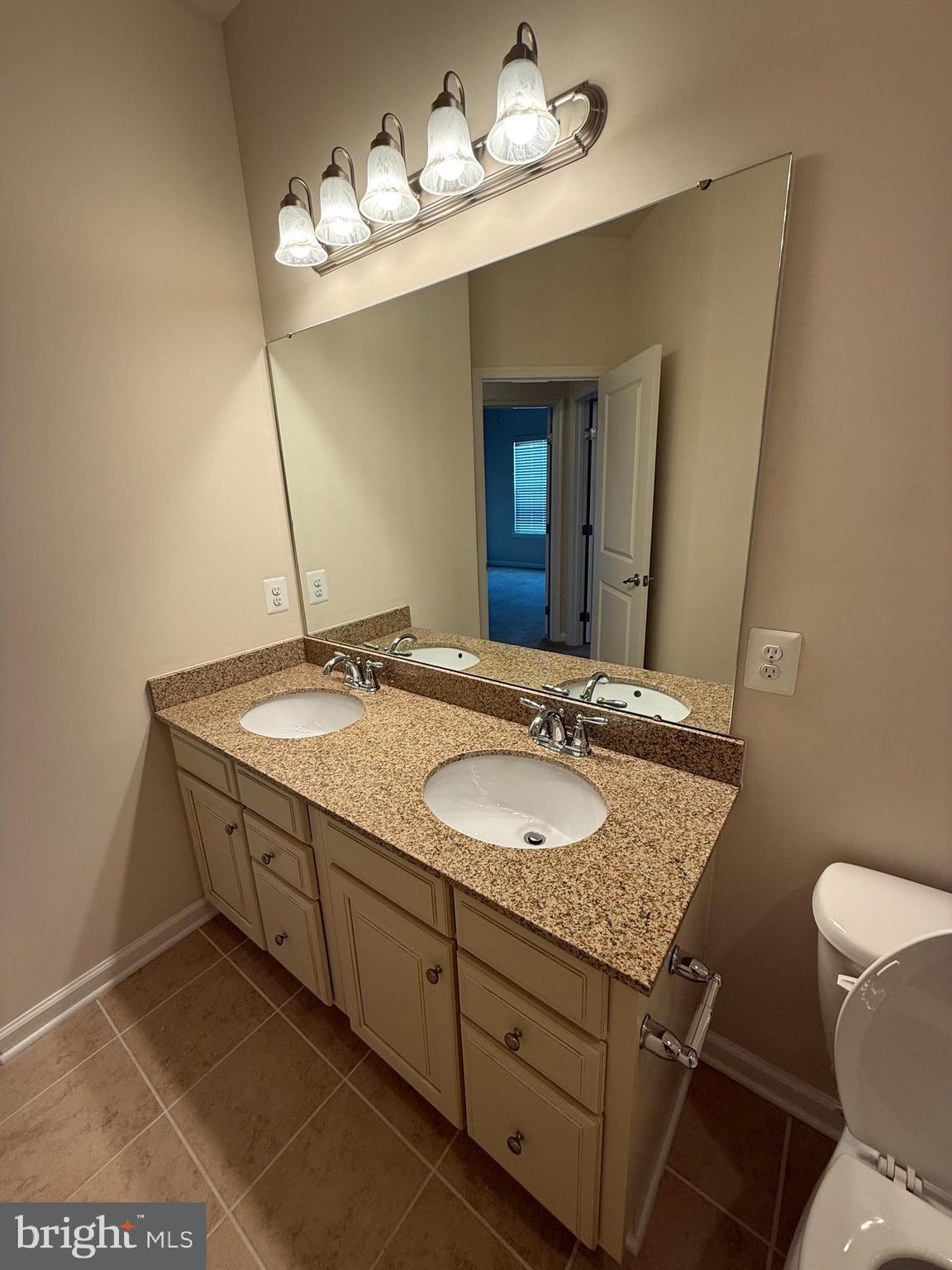 202 B Mill Pond Road Frederick, MD 21701 - Photo 38 of 44 a bathroom with a granite countertop sink a large mirror and a toilet