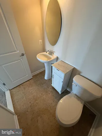 a bathroom with a toilet mirror and sink