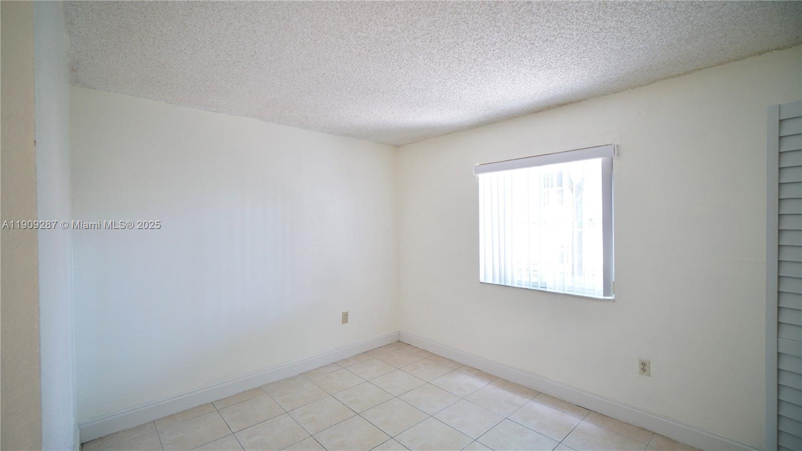 15231 Southwest 80th Street, Unit 101 Miami, FL 33193 - Photo 11 of 19 an empty room with a window