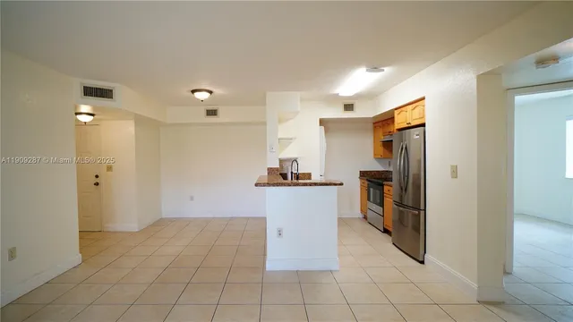 a kitchen with granite countertop a refrigerator and a sink